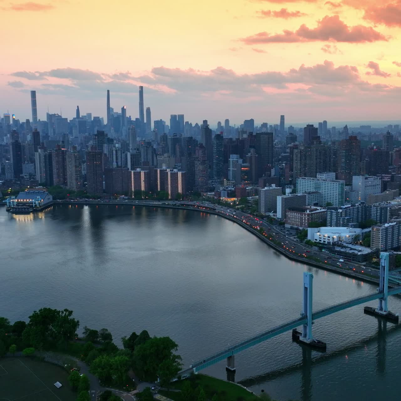 Beautiful Wards Island Bridge over Harlem River in New York. Gorgeous cityscape at the backdrop of pink cloudy sky