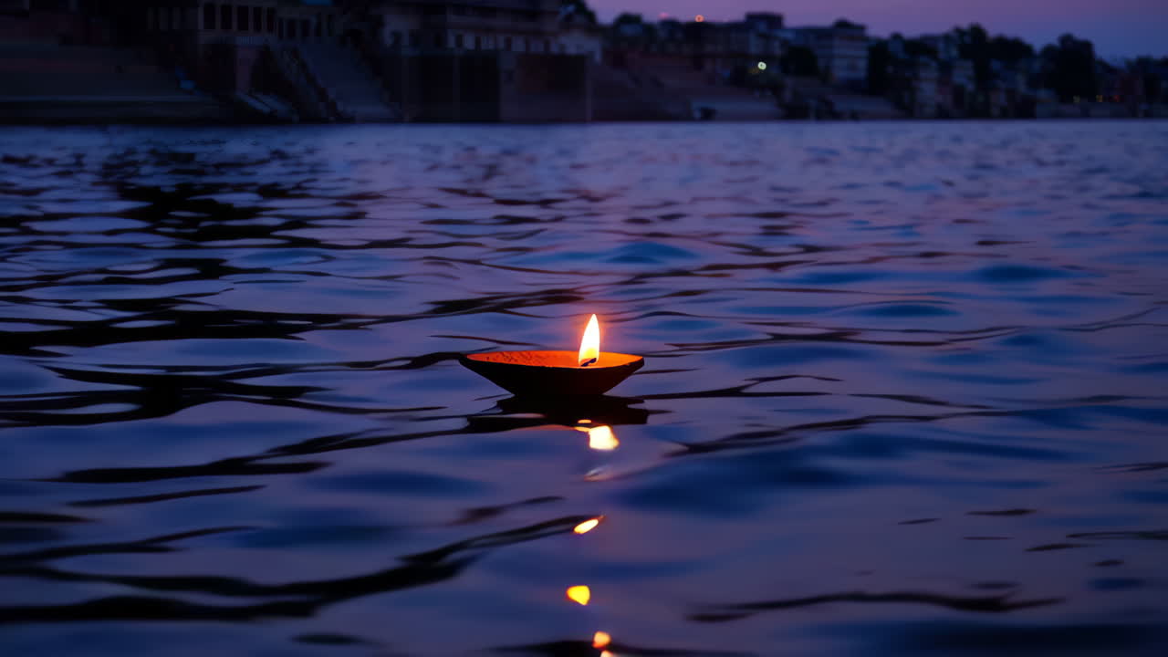 Diya che galleggia sul fiume Gange al crepuscolo