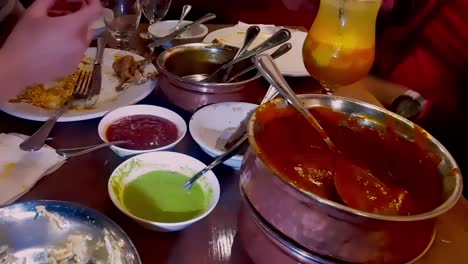 2 adult male ethnic people enjoying mass variations of food during dinner at an authentic pakistani resturaunt with unique fusion of traditional and modern home made nourishments in india eatery