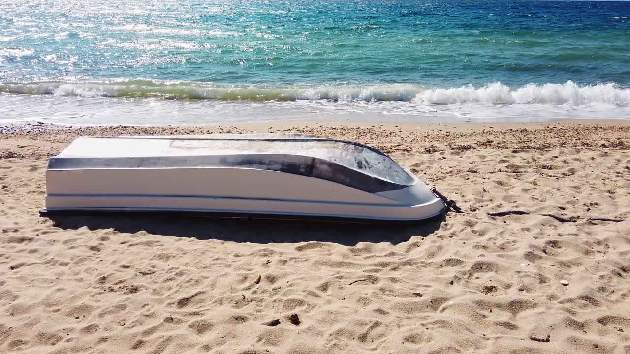 Barca capovolta su una spiaggia, onde del Mar Egeo a Nikiti, Grecia