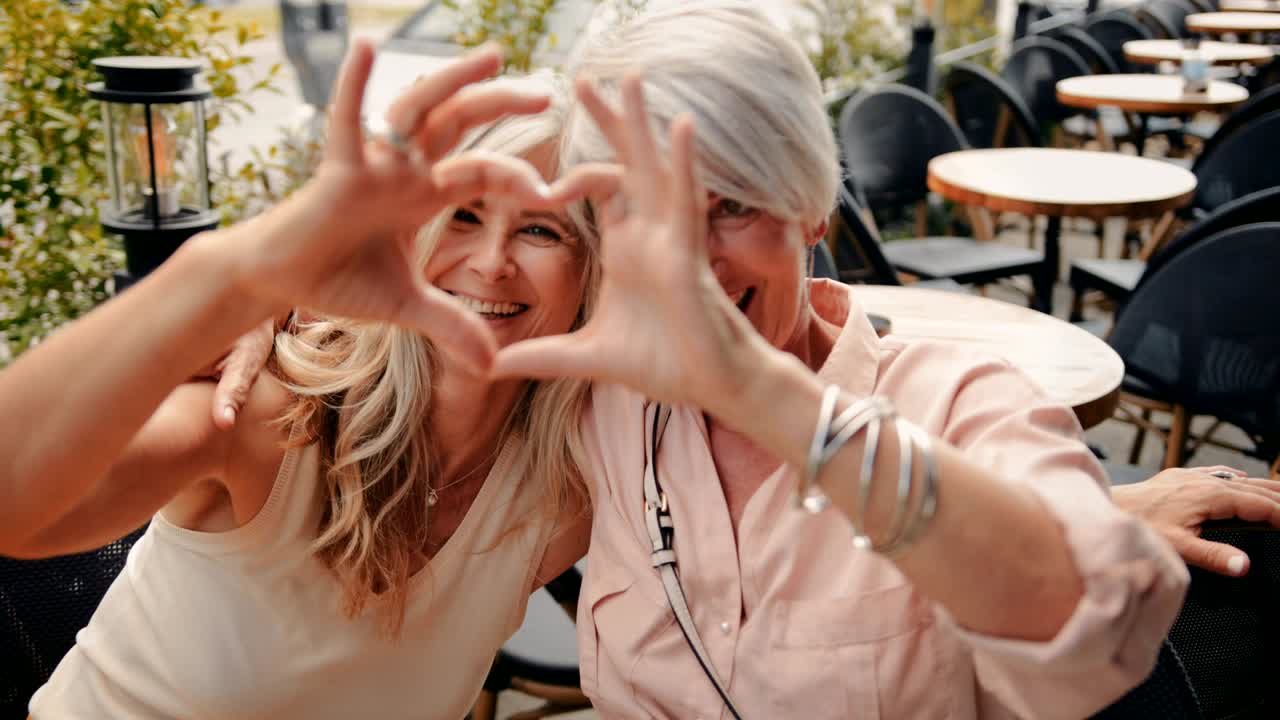 행복한 성숙한 여성들이 손으로 심장 모양을 만니다.