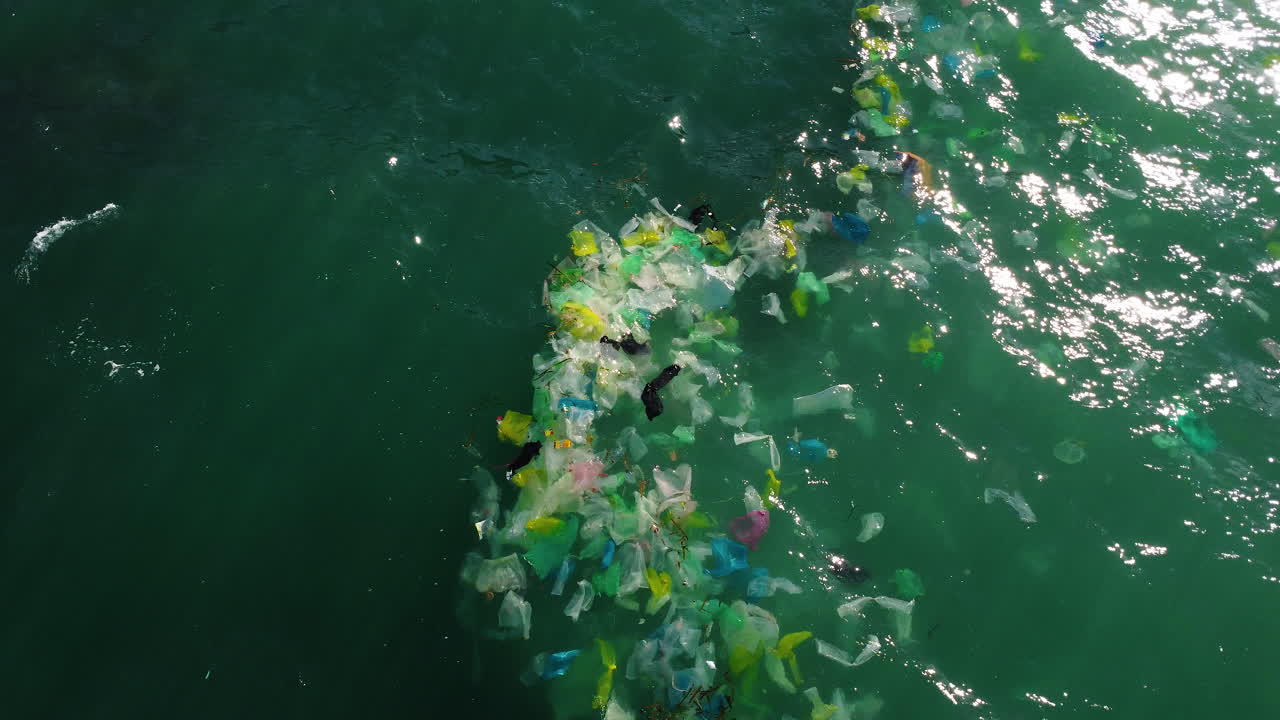Ripresa aerea, spazzatura di plastica che galleggia sull'oceano turchese.