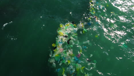 Aerial,-plastic-garbage-floating-on-turquoise-ocean