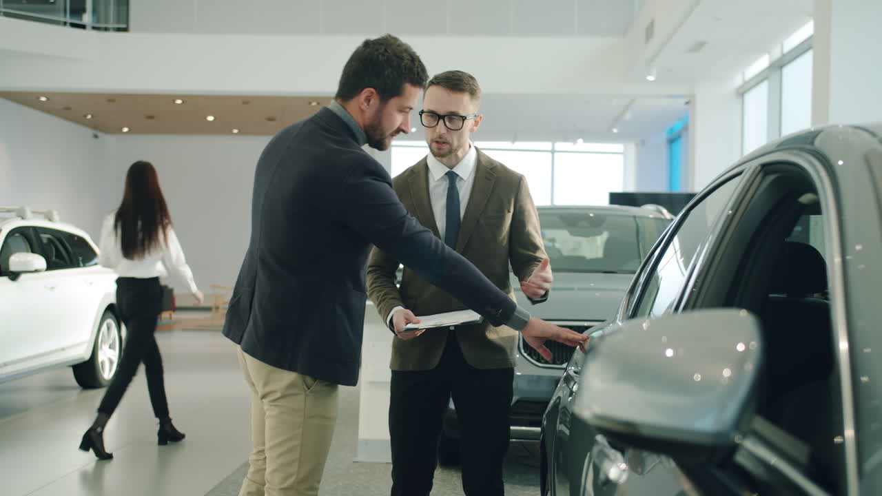 Car Salesman Discussing Car Features with Customer in Showroom