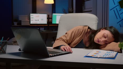 exhausted tired businesswoman sleeping on desk table in startup business office