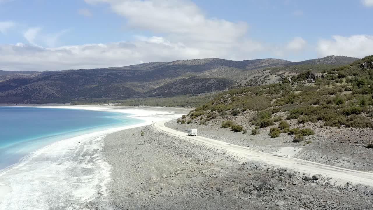 Motorhome travels along scenic dirt road towards Turkish hills around Lake Salda