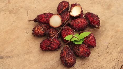 Lychee-with-leaves-isolated-on-wood-background