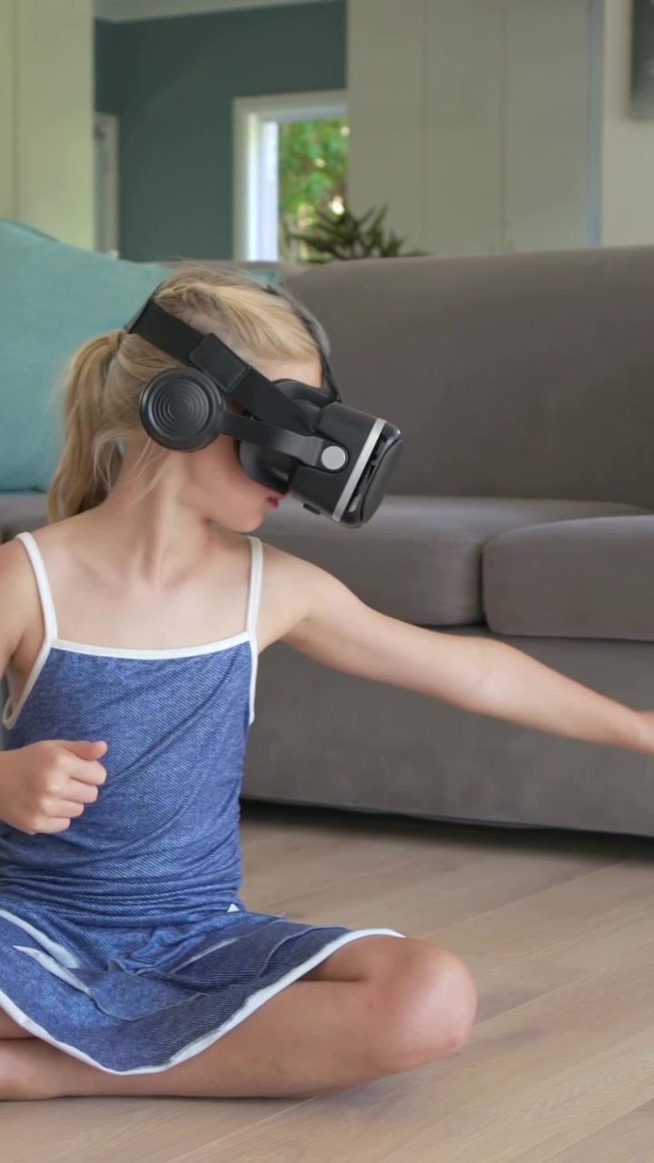 Mujer joven sentada en el suelo usando gafas de realidad virtual, siguiendo una interfaz de usuario animada al iniciar una aplicación de tecnología.