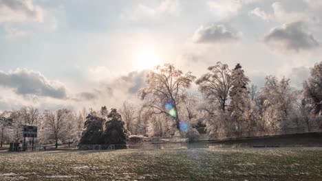 Zeitraffer:-Ein-Wunderschöner-Sonnenuntergang-über-Einem-Gefrorenen-Fußballfeld-Mit-Großen-Weißen,-Eisigen-Bäumen-In-Der-Ferne