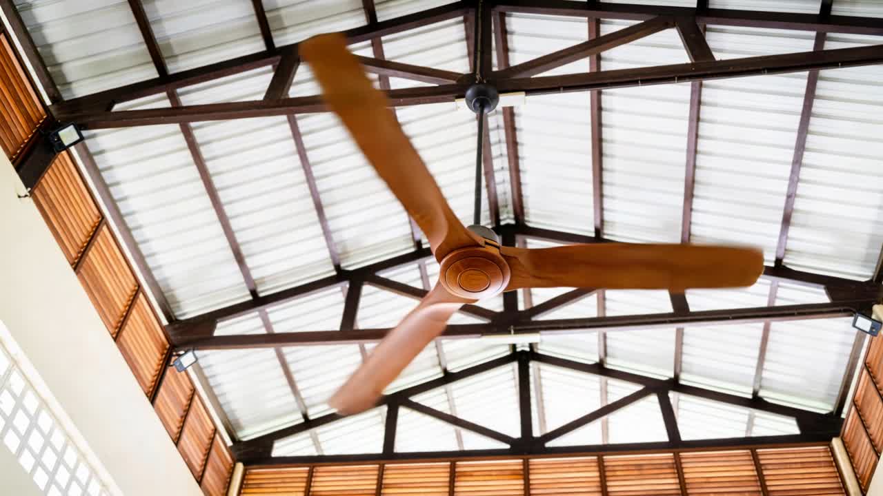 Motore di ventilatore a soffitto che alimenta le pale che ruotano attraverso i fotogrammi, un'ispezione HVAC che mostra un effetto mosso.