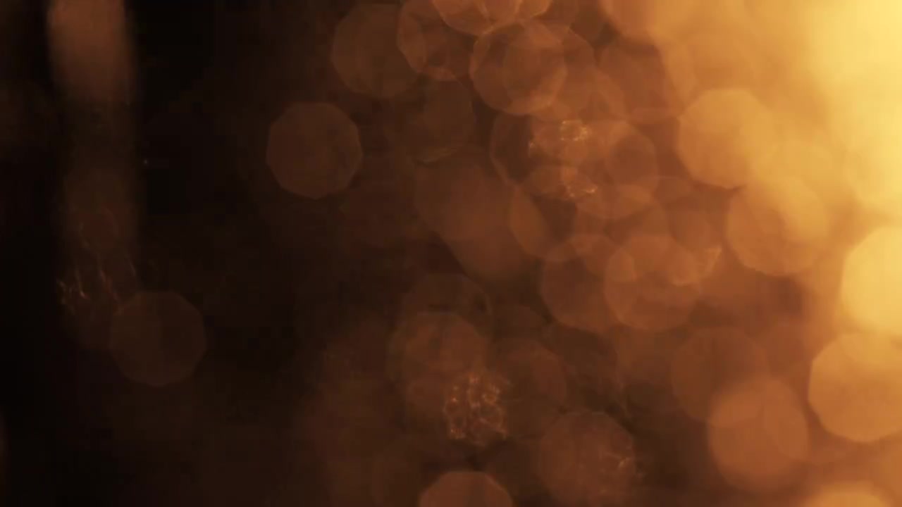 Sovrapposizione Astratta Bokeh di Luce Dorata su Sfondo Nero