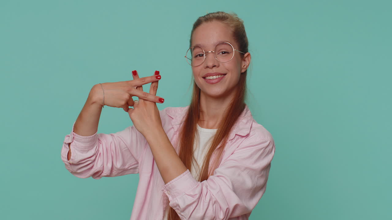 Adolescente alegre mostrando el símbolo de hashtag con las manos, en referencia a un mensaje etiquetado o contenido viral popular.