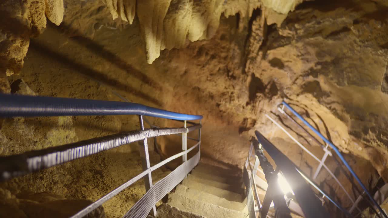Interior stone walls with staircase access inside Labouiche underground river cave in Ariège, France