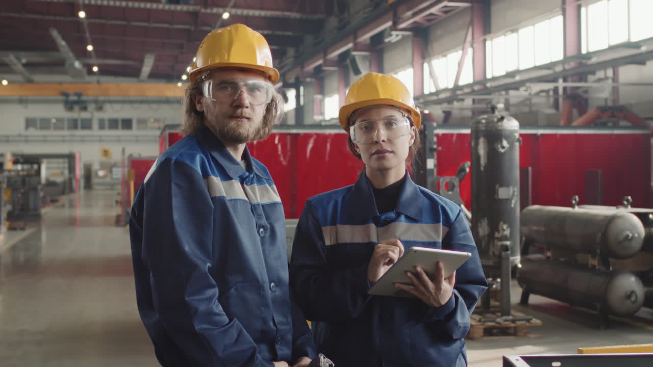 Portrait Of Factory Workers In Safety Glasses With Tablet