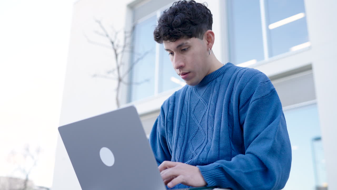 Young male using netbook outside building
