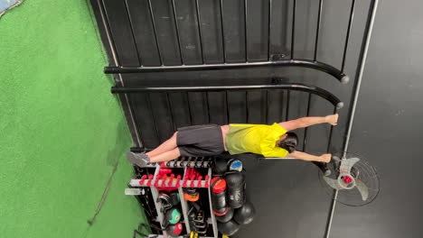 latin man with beard and long hair performing exercise on chin-up bar