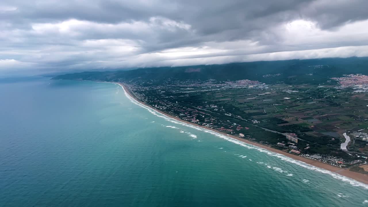 video 4k capturando una vista aérea de la costa de barcelona desde una ventana de un avión
