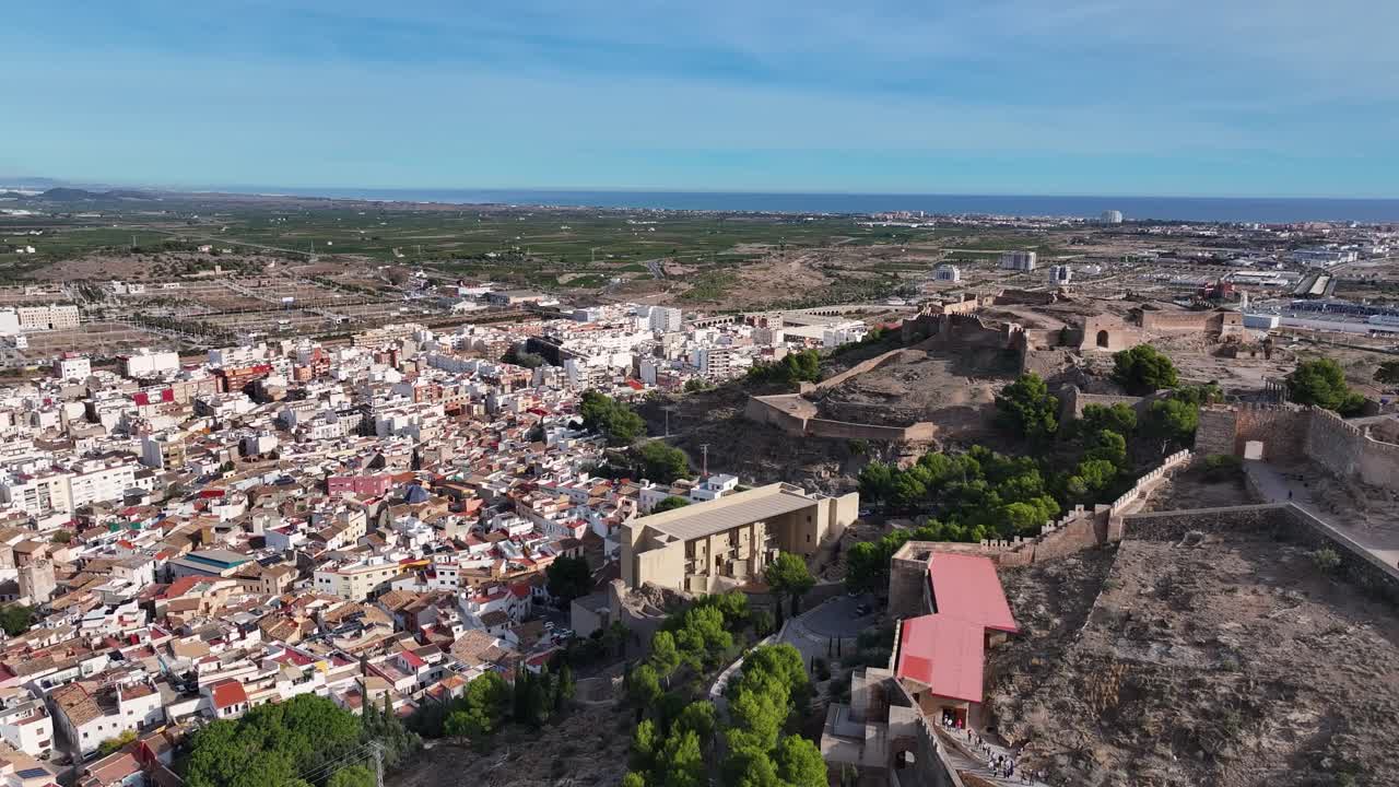 vuelo donde vemos la colina y el castillo en un lado en el otro la ciudad de sagunto donde llegamos a ver el teatro romano y en el fondo el mar azul y el cielo en valencia españa