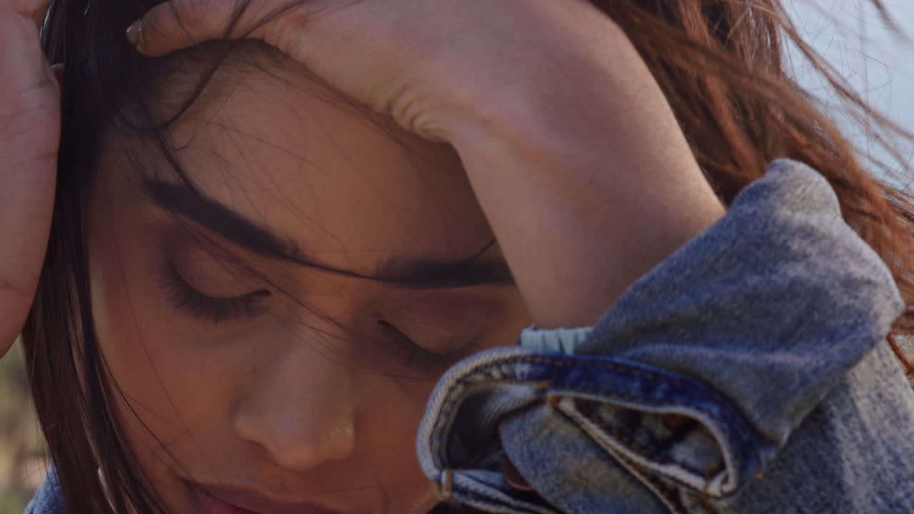 retrato en primer plano de una hermosa mujer india disfrutando de un tranquilo día soleado relajándose en las vacaciones de verano con el viento soplando el cabello