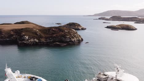 descending drone shot showing the islands of uist and a fish farming boat