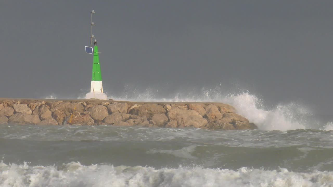 Crashing waves and stormy seas on harbor wall