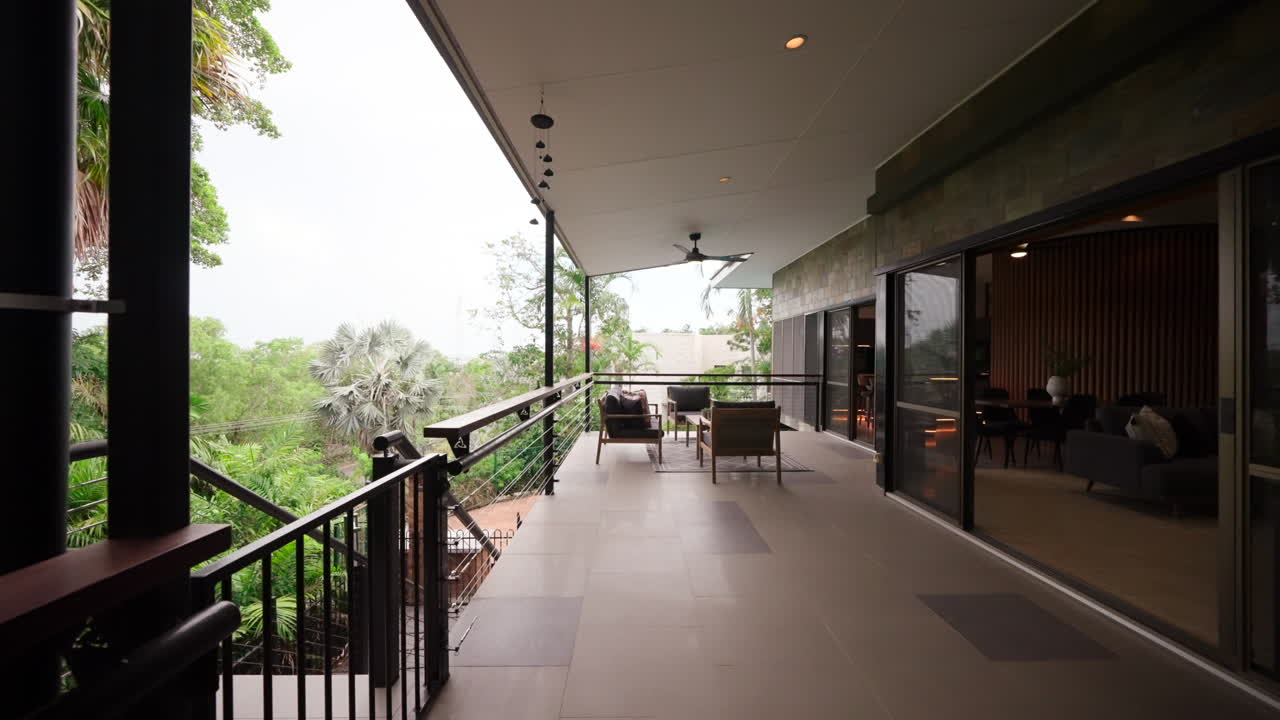 casa elevada de lujo tropical hogar exterior área al aire libre patio veranda con mesa y sillas al aire libre seguir hasta el área de salón al aire libre tarde en la tarde
