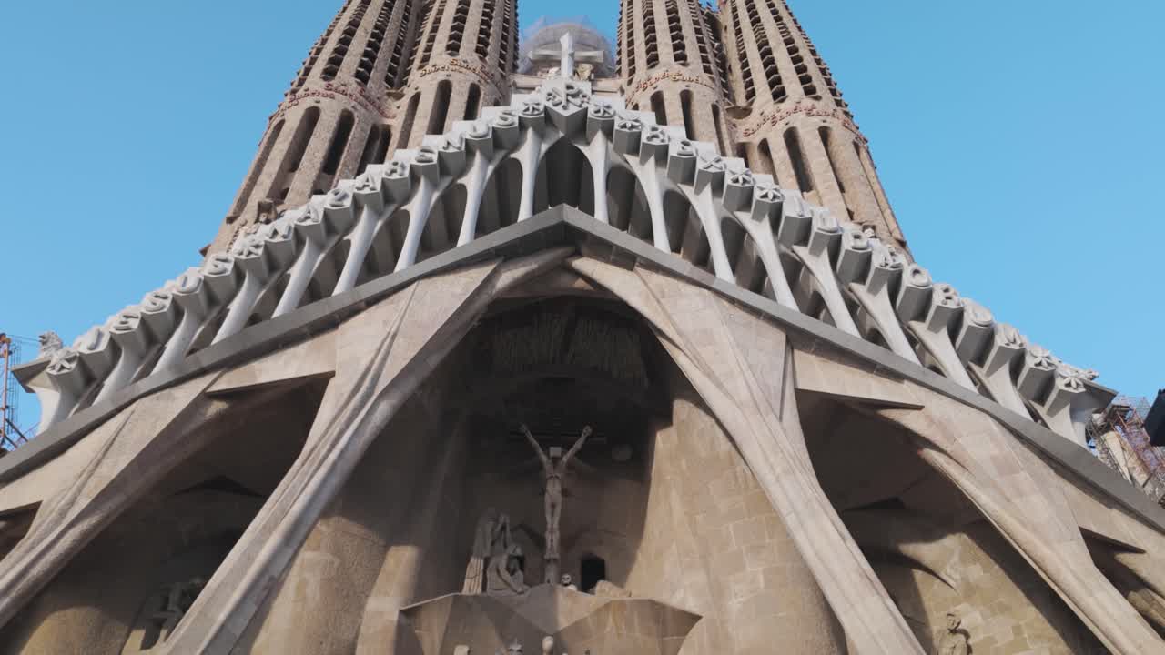 The intricate architectural design of the Sagrada Família spires viewed against a backdrop of clear sky. Captures the iconic church's essence and its place in architectural history.