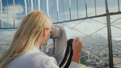 a woman looks at a beautiful view of new york from the observation deck the wind plays with her hair