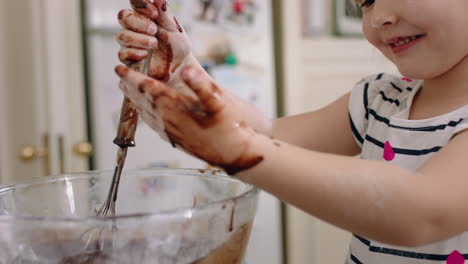 happy little girl helping mother bake in kitchen having fun mixing ingredients with mom preparing recipe at home