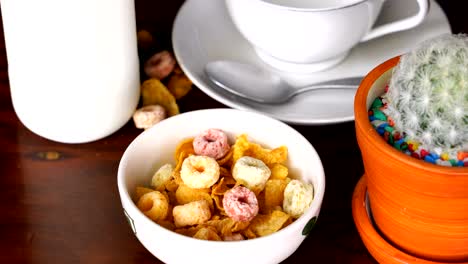 pouring milk into a bowl of corn flakes and froot  loops