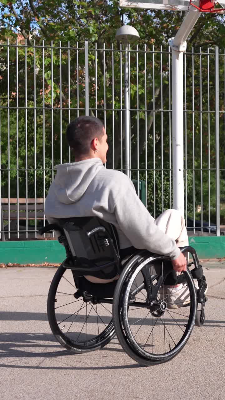 Young Man in Wheelchair High-Fiving Friend on Basketball Court