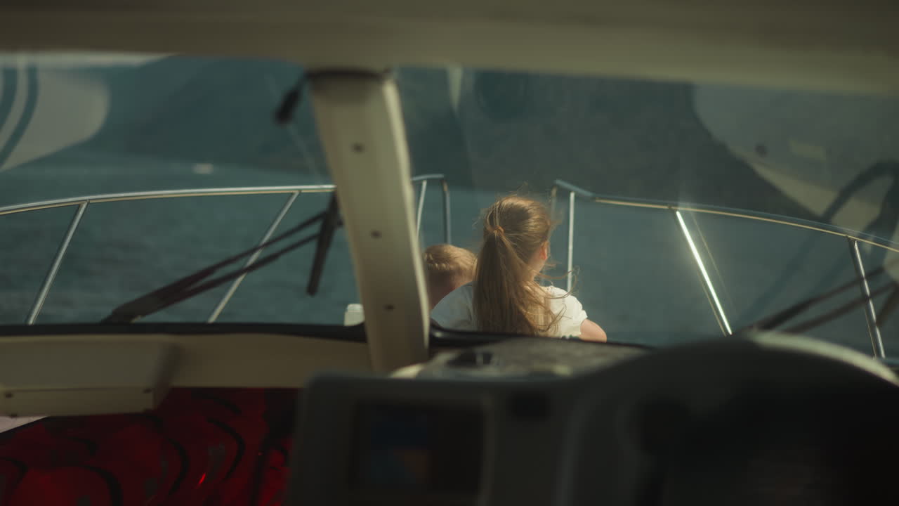 조종사 에서 보이는 동생과 함께 모터 보트를 타고 있는 소녀 포인트. 행복한 아이들은 휴가 중 현대 요트를 타고 이국적인 풍경을 즐기고 있습니다.