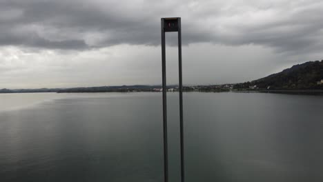 el tranquilo lago constance en un día nublado por la tarde apreciando un polo alto junto a la hermosa ciudad alpina de bregenz en austria, vista aérea vertical