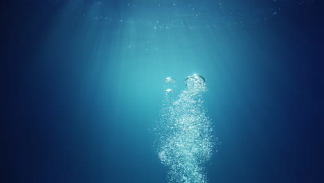 underwater sunlight beams shining from above coming through the deep crystal clear blue water causing a beautiful water lighting reflections curtain with air bubbles rising up to the surface