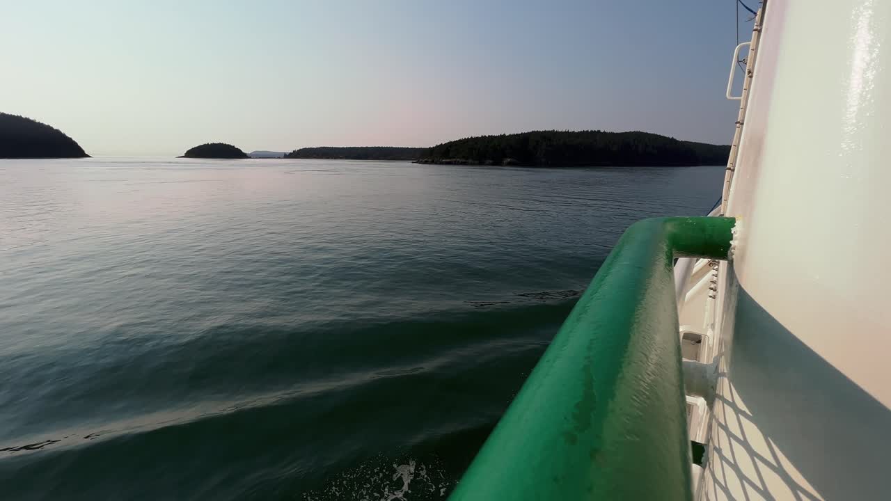 Perspektive eines Passagiers auf einer Fähre mit Blick auf das ruhige Wasser der Rosario Strait in der Abenddämmerung in Washington, USA