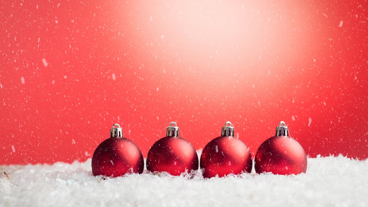animación de adornos de bolas de navidad con nieve cayendo sobre un fondo rojo