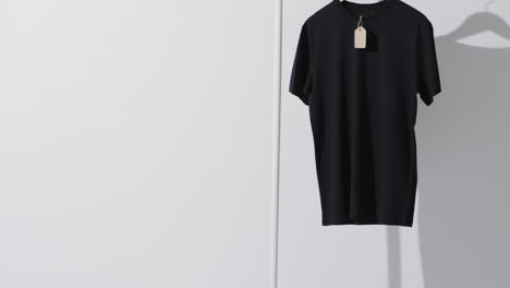 Video-of-black-t-shirt-on-hanger-and-copy-space-on-white-background