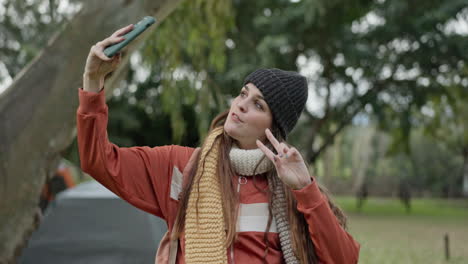 Selfie,-camping-and-woman-in-forest-with-peace