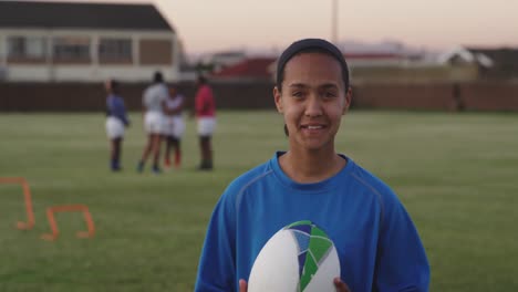 portrait of young adult female rugby player on a rugby pitch
