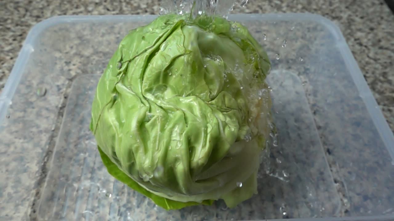 Washing of cabbage under a water jet. Slow motion