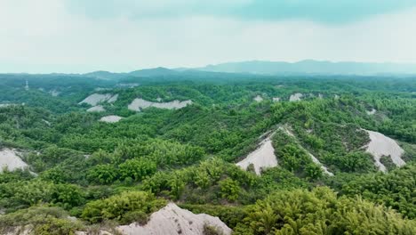 Foggy-day-with-clouds-over-badlands-and-green-plants-at-Moon-World-of-Tianliao