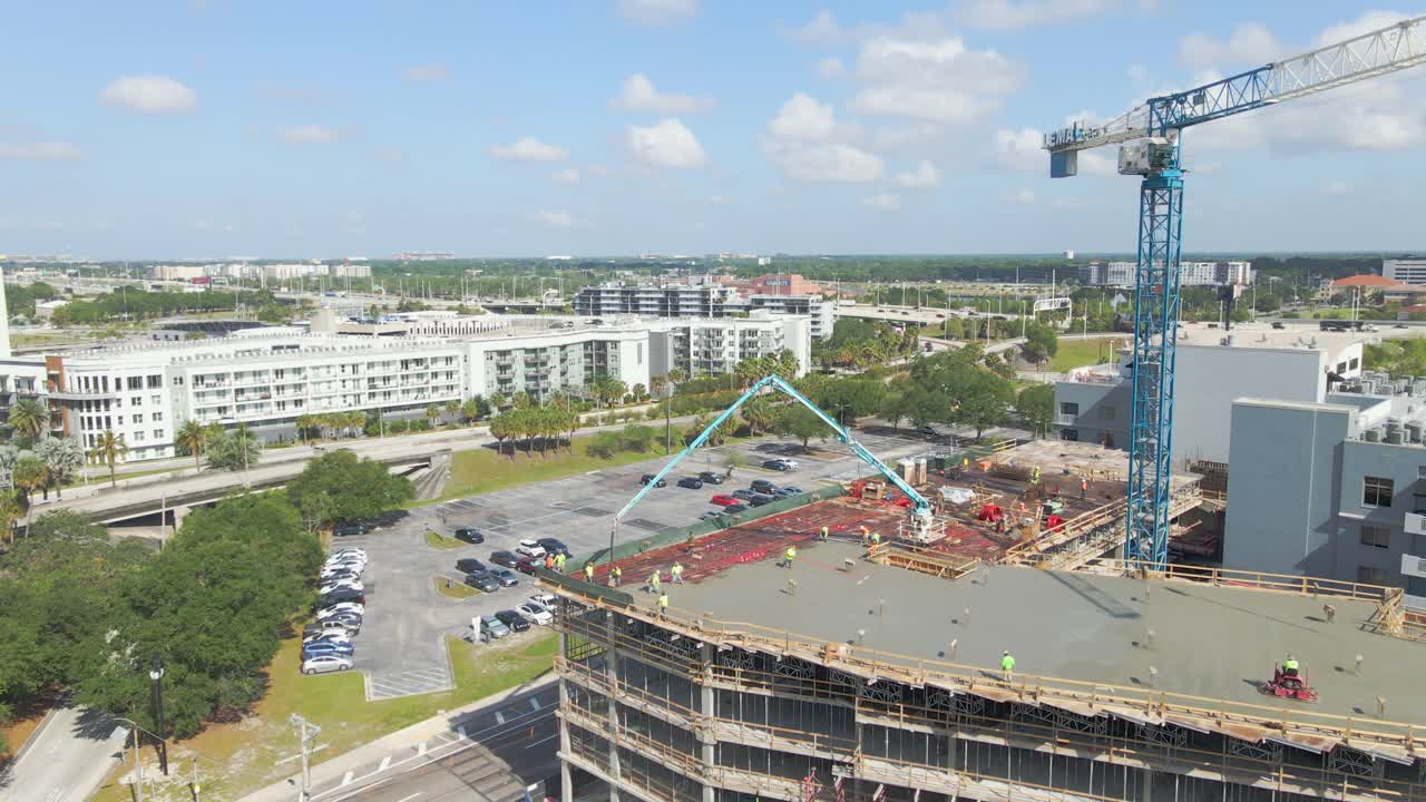 Crew of concrete workers pouring cement on a downtown building