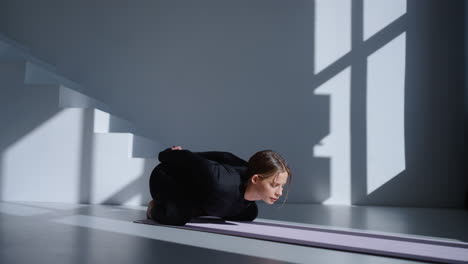 mujer practicando yoga en un estudio