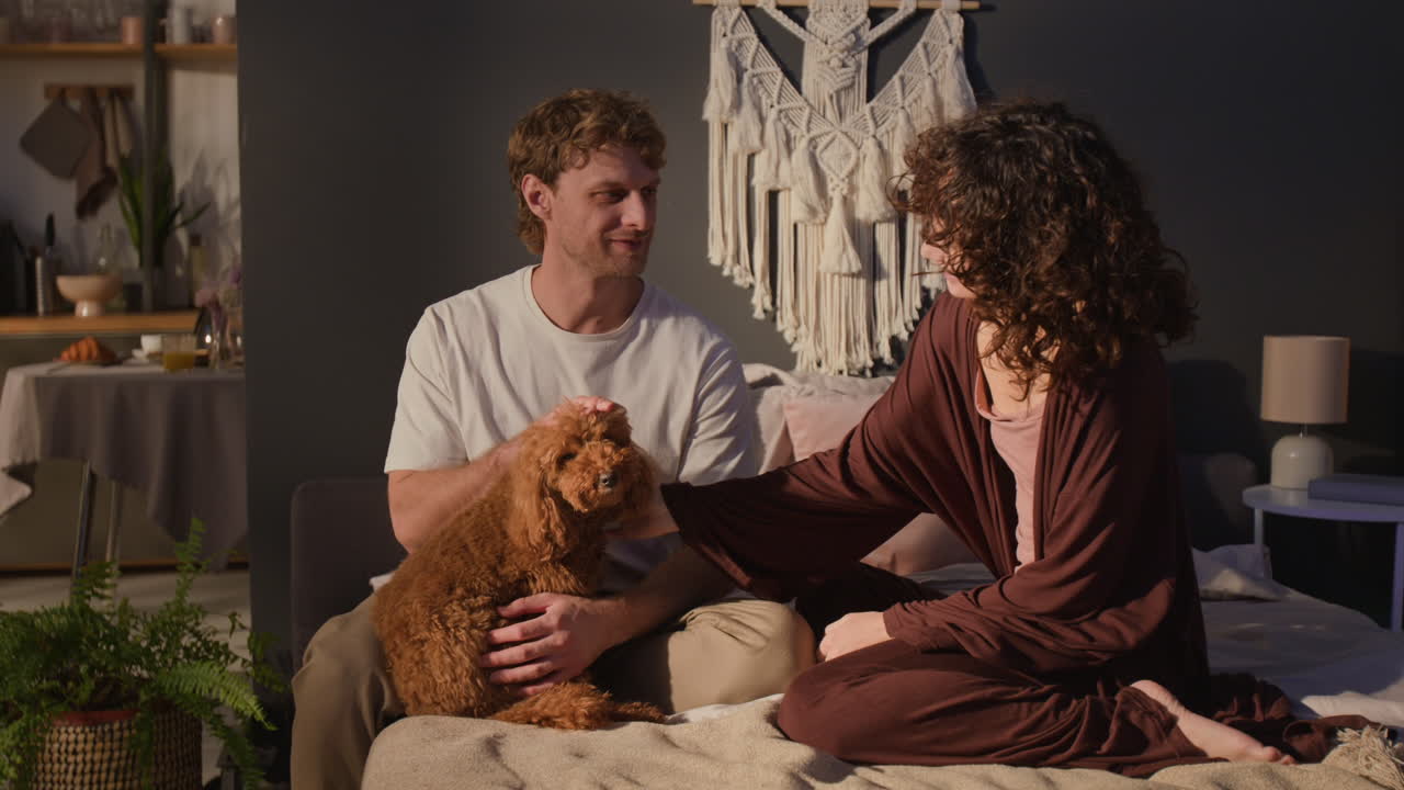 Couple cuddling with their dog at home