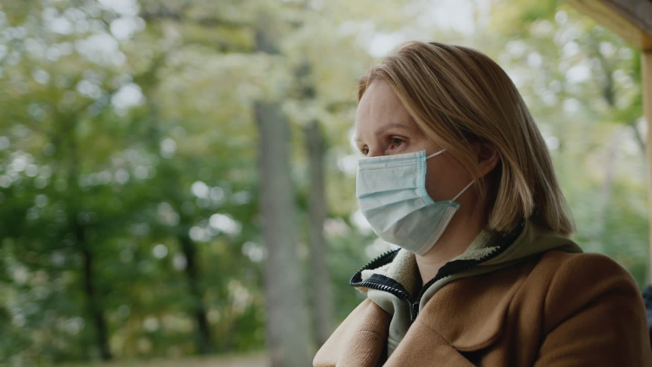 의료 마스크를 입은 여성이 트램을 타고 전염병의 확산을 막고 있습니다.