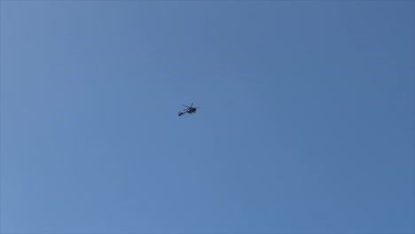helicóptero flotando en la distancia contra un cielo azul brillante