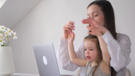 a workathome mom on maternity leave mother works at the computer with her child a workathome mom on maternity leave mother works at the computer with her child the child interferes with the mothers work at the computer