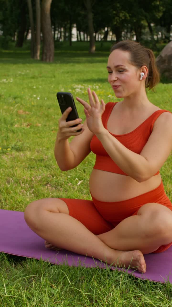 mujer embarazada haciendo yoga en el parque