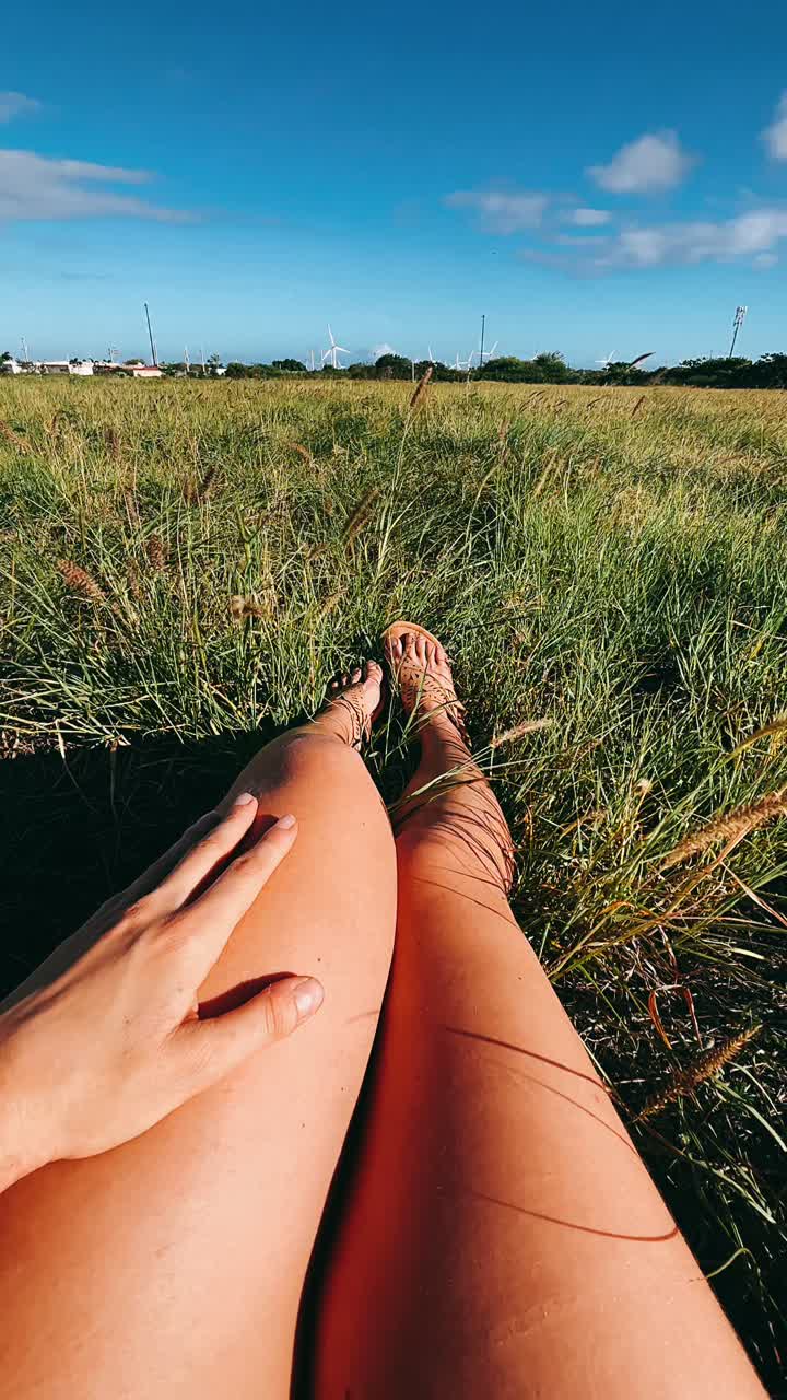 relajándose en un campo cubierto de hierba con turbinas eólicas