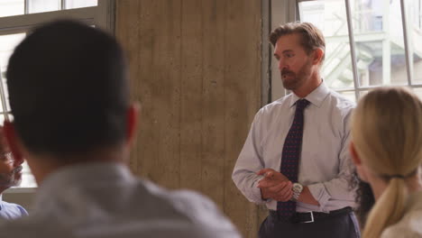 Middle-aged-businessman-stands-leading-a-meeting,-close-up